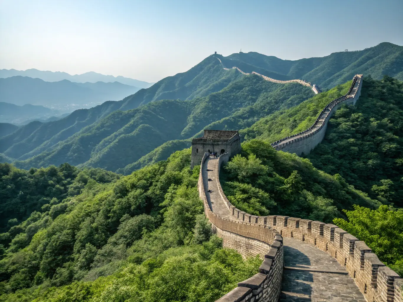 A stunning photograph of the Great Wall of China winding through the mountains, showcasing its historical significance and breathtaking scenery, with a clear blue sky above.